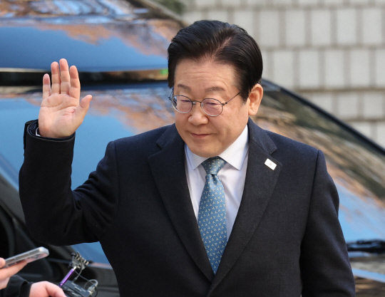 이재명 더불어민주당 대표가 4일 오전 서울 서초구 서울중앙지방법원에서 열린 '대장동 배임·성남FC 뇌물' 1심 속행 공판에 출석하기 위해 법원 청사에 도착한 뒤 지지자들을 향해 손을 들어 인사하고 있다.<공동취재·연합뉴스>